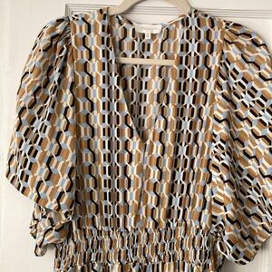 Geometric print dress in brown, beige, and blue with handkerchief hem